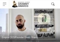 a man with a beard is standing in front of a poster of the grammy awards