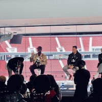a group of people sitting on chairs in front of a stadium
