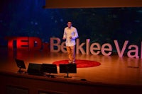 a man standing on stage at a tedx event